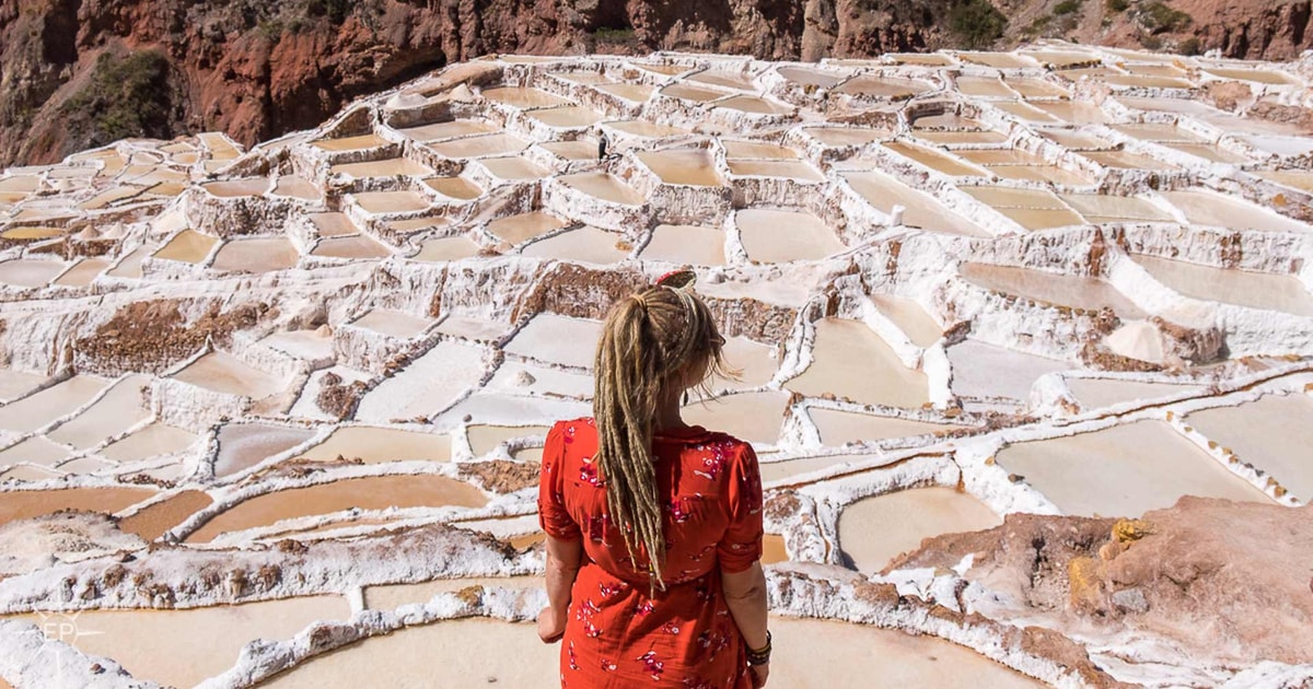 Woman admiring the Maras Salt Mines from a viewpoint, highlighting the beauty of the Maras and Moray Salt Mines tour.