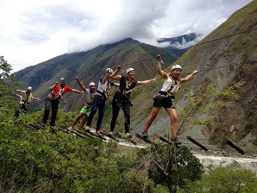 Group of hikers crossing a suspension bridge during the 4-day, 3-night Inca Jungle Trek.
