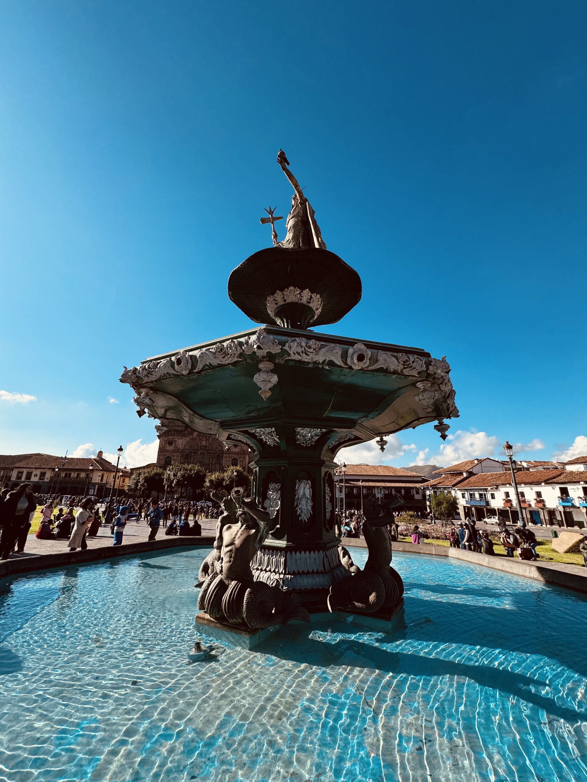 Historic fountain in the Plaza de Armas of Cusco under a blue sky, highlighting a half-day tour of the city of Cusco.
