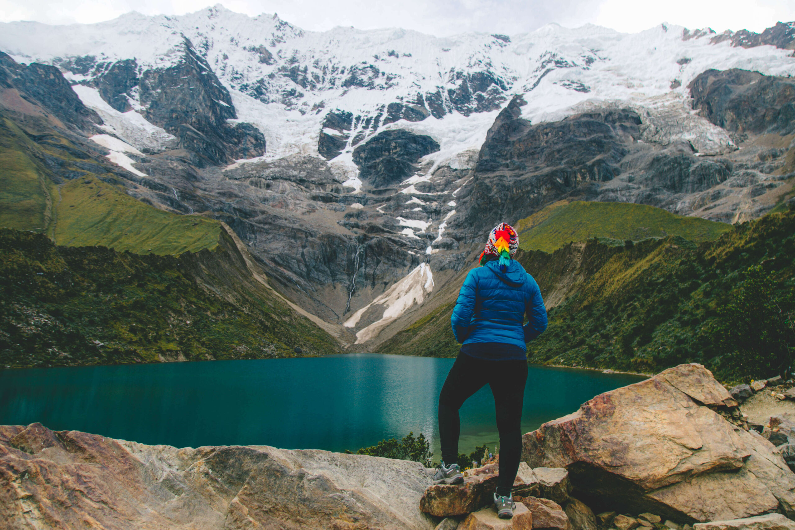 Hiker on his back admiring the Humantay Lake in the Salkantay Pass 2 days.