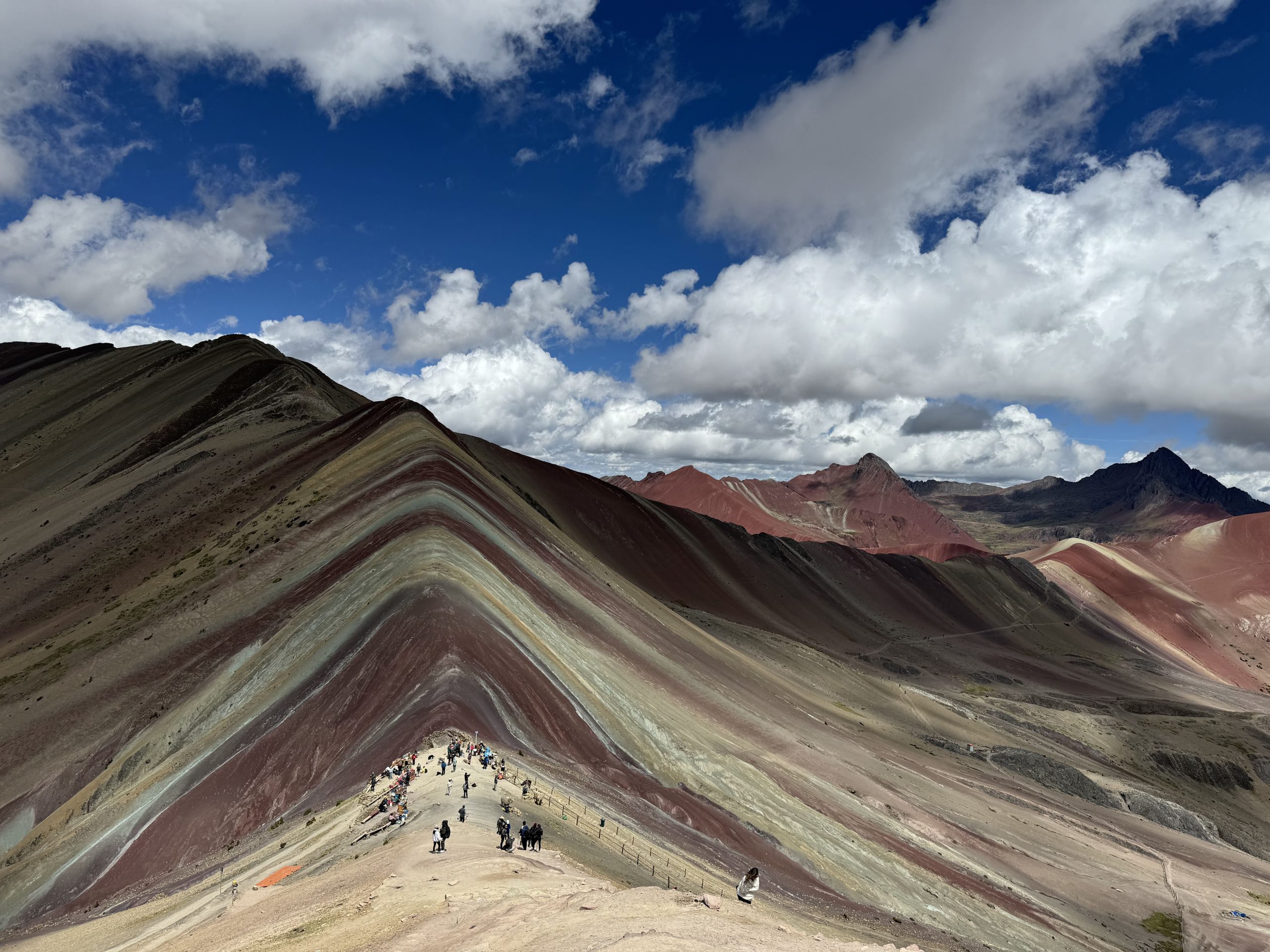 An aerial view of Vinicunca Rainbow Mountain with hikers, ideal for a full-day tour.