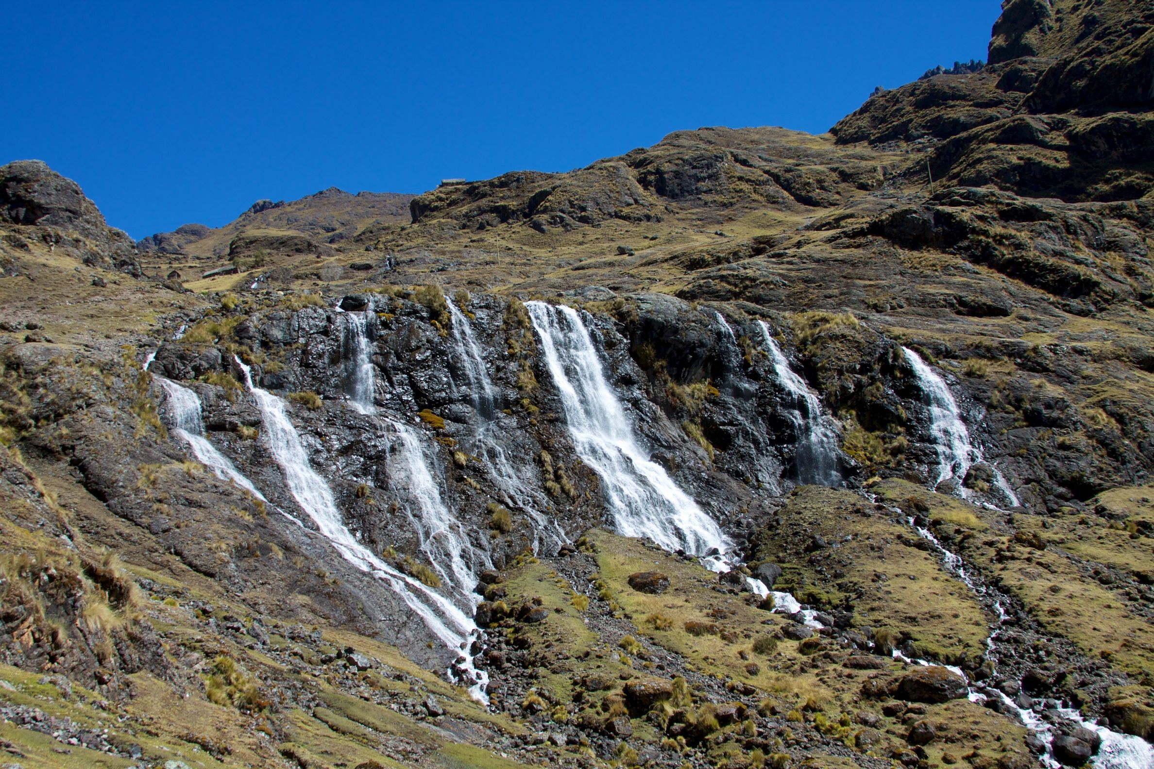 Several waterfalls cascading down a mountainside on the Lares trek to Machu Picchu 4 days and 3 nights.